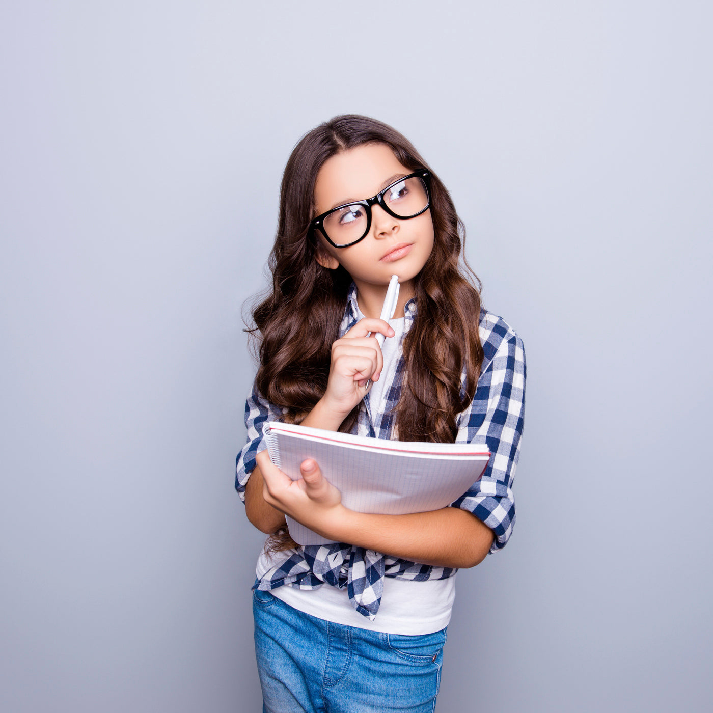 girl thinking as she's writing her journal