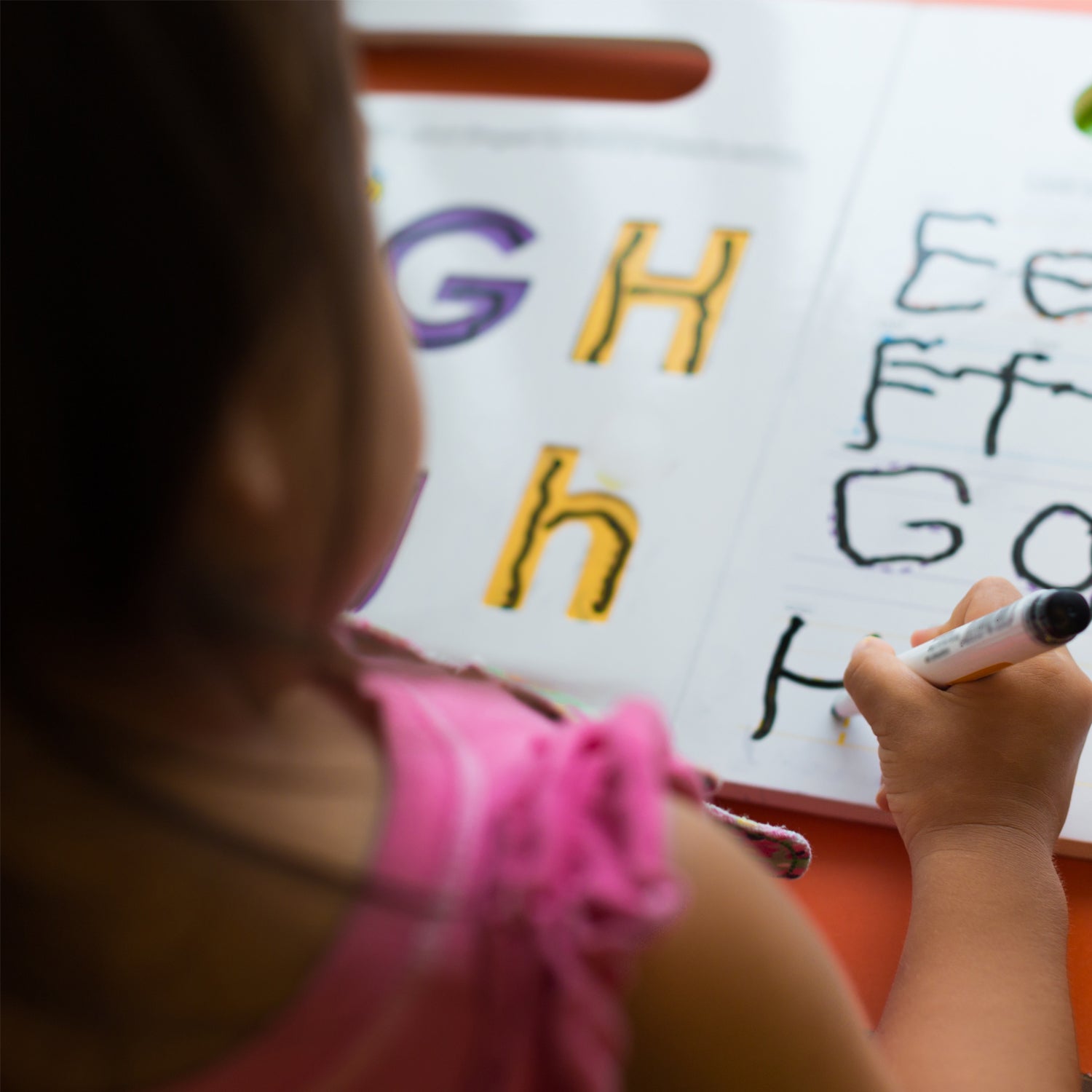 girl tracing letters